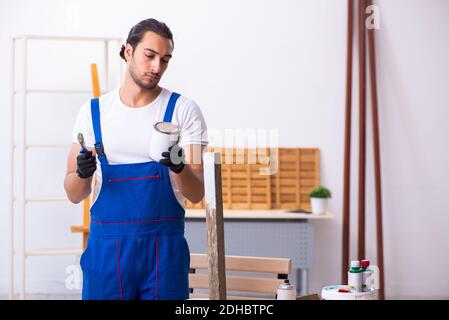 Junge männliche Auftragnehmer in der Werkstatt arbeiten Stockfoto