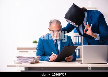 Alter Geschäftsmann Angestellter bekommt Deal mit dem Teufel Stockfoto