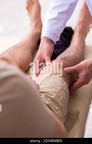 Erfahrener Arzt Traumatologe Untersuchung junger männlicher Patient Stockfoto
