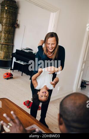 Vater und Mutter spielen mit fröhlichen Tochter zu Hause Stockfoto