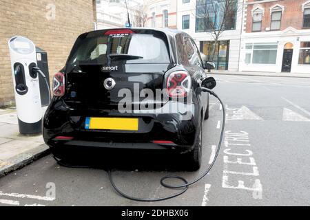 Kleines elektrisches SMART-Auto, das in London aufgeladen wird Stockfoto