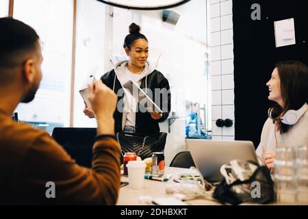 Glückliche junge multi-ethnische Programmierer diskutieren in kleinen kreativen Büro Stockfoto