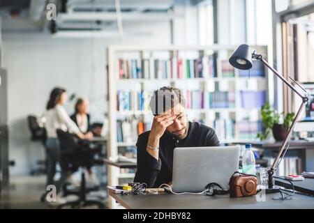 Besorgt männlichen Unternehmer Blick auf Laptop, während im Büro sitzen Stockfoto