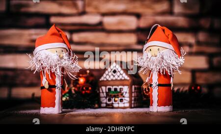 Zwei lustige Weihnachtsmann auf dem Hintergrund einer Lebkuchenhaus. Stockfoto