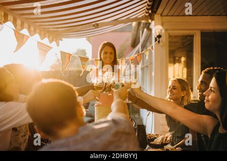 Fröhliche multi-ethnische Freunde toasten Weingläser beim Genießen bei der Dinner-Party Stockfoto