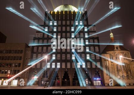 Hannover, Deutschland. Dezember 2020. Beleuchtete Fenster lassen im Rahmen eines Adventkalenders die Zahl 10 an der Fassade des Anzeiger-Hochhauses erstrahlen - Autos fahren abends am Denkmal vorbei (Aufnahme mit langer Belichtungszeit; Zoom-Effekt). Quelle: Moritz Frankenberg/dpa/Alamy Live News Stockfoto