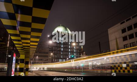 Hannover, Deutschland. Dezember 2020. Beleuchtete Fenster lassen im Rahmen eines Adventkalenders die Zahl 10 an der Fassade des Anzeiger-Hochhauses erstrahlen - abends fährt eine Straßenbahn am Denkmal vorbei (Aufnahme mit langer Belichtungszeit). Quelle: Moritz Frankenberg/dpa/Alamy Live News Stockfoto