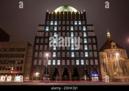 Hannover, Deutschland. Dezember 2020. Beleuchtete Fenster lassen im Rahmen eines Adventkalenders die Zahl 10 an der Fassade des Anzeiger-Hochhauses erstrahlen - Autos fahren abends am Denkmal vorbei (Aufnahme mit langer Belichtungszeit). Quelle: Moritz Frankenberg/dpa/Alamy Live News Stockfoto