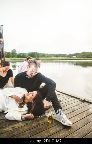 Ein lächelndes Paar mit Freunden auf dem Steg über dem See am Wochenende Kurzurlaub Stockfoto