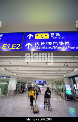 Transfer-Schilder in Hong Kong Flughafen Trolley Passagiere und Gepäck Stockfoto