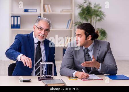 Zwei Geschäftsleute und Meditationskugeln auf dem Tisch Stockfoto