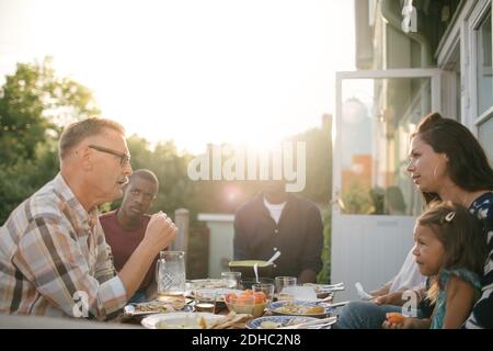 Multi-Generation-Familie mit Mittagessen am Tisch auf der Veranda während der Sonne Tag Stockfoto