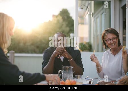 Lächelnde Familie mit mehreren Generationen, die am Tisch auf der Veranda zu Mittag gegessen hat Stockfoto