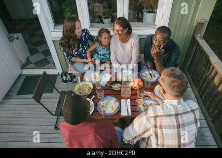 Blick auf die Familie mit mehreren Generationen, die am Tisch zu Mittag essen Auf der Veranda Stockfoto