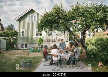 Familie mit mehreren Generationen, die während der Gartenparty Getränke auf der Terrasse genießt Stockfoto