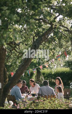 Multi-Generation-Familie mit Mittagessen im Hinterhof während Gartenparty Stockfoto