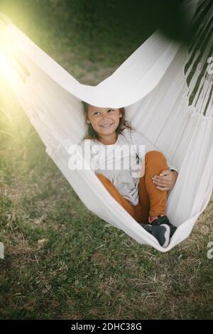 High-Angle-Ansicht des Mädchens in der Hängematte im Hinterhof entspannen Stockfoto