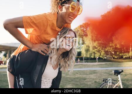 Glücklich junge Frau Huckepack Mann trägt Neuheit Brille Stockfoto