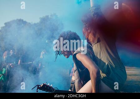 Mann Huckepack inmitten blauer Pulverfarbe während der Feier Holi Stockfoto