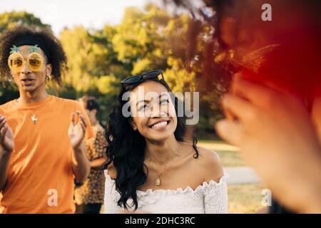 Fröhliche junge Frau tanzen mit Freunden in Musik-Event Stockfoto