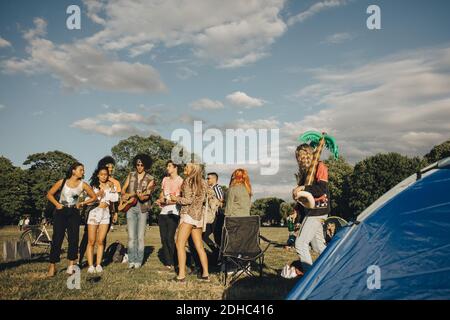 Multiethnische Freunde genießen Musik bei Veranstaltung gegen Himmel auf sonnig Tag Stockfoto