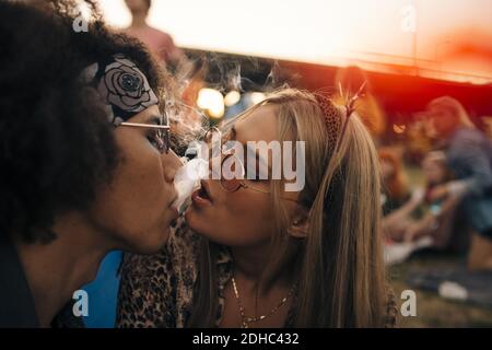 Nahaufnahme eines Paares, das bei einer musikalischen Veranstaltung zusammen raucht Stockfoto