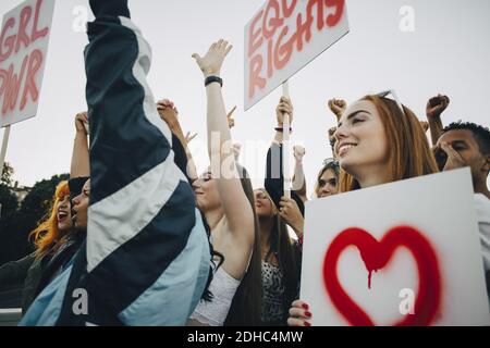 Niedrige Ansicht lächelnder Frauen, die mit Spruchbändern protestieren Stadt Stockfoto