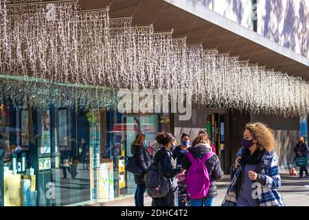 Barcelona, Spanien. Dezember 2020. Ein Haufen Leute vor dem weihnachtlich geschmückten Haupteinkaufszentrum El Corte Inglés an der Plaza Catalonia, dem Hauptplatz von Barcelona. Kredit: Dino Geromella / Alamy Live Nachrichten Stockfoto