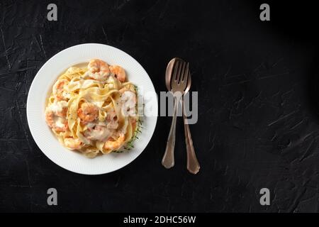 Italienische Pasta. Pappardelle mit Garnelen und Cremesoße, Overhead-Shot mit Kopierraum Stockfoto