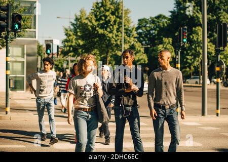 Männliche Freunde überqueren Straße in der Stadt Stockfoto