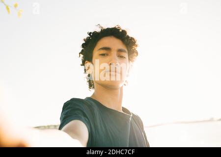 Porträt eines Jungen im Teenageralter gegen den klaren Himmel an sonnigen Tagen Stockfoto
