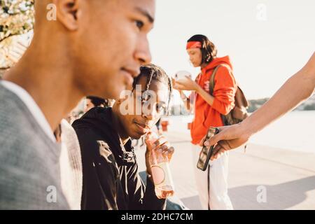 Porträt eines Teenagers, der mit Freunden trinkt An sonnigen Tagen auf der Promenade Stockfoto