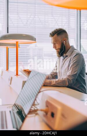 Selbstbewusster Geschäftsmann mit digitalen Tablet während der Wartezeit am Flughafen Stockfoto