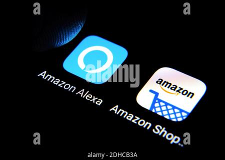 Amazon Alexa und Amazon Shopping Apps werden auf dem Smartphone-Bildschirm angezeigt ein Finger berührt den Bildschirm Stockfoto