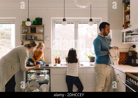 Vierköpfige Familie, die zu Hause in der Küche arbeitet Stockfoto