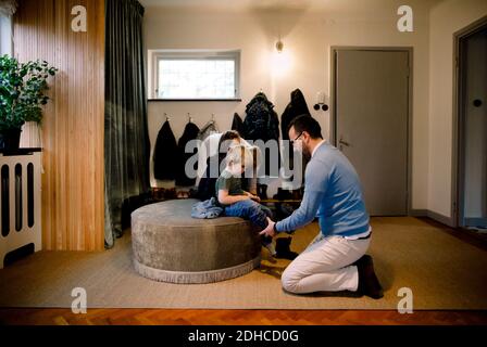 Vater hilft Tochter in Schuhe zu Hause tragen Stockfoto