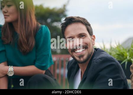 Portrait von lächelnden bärtigen Mann genießen Party mit Freund auf Terrasse Stockfoto