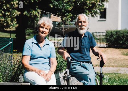 Portrait von lächelndem Rentner und Frau, die an sitzen Hinterhof Stockfoto