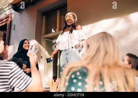 Multiethnische junge Freunde feiern auf dem Balkon während der Party Stockfoto