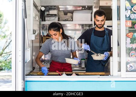 Selbstbewusste junge, multiethnische Kolleginnen und Kollegen, die in der Lebensmittelverarbeitung arbeiten LKW Stockfoto