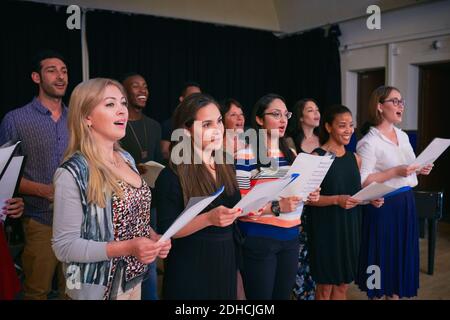 Männliche und weibliche Freunde üben Chor auf der Bühne im Auditorium Stockfoto