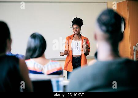 Selbstbewusste junge Frau gesturing während der Lehre Studenten in der Klasse Stockfoto