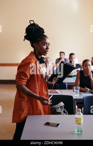 Selbstbewusster junger Schüler mit digitalem Tablet im Klassenzimmer Stockfoto