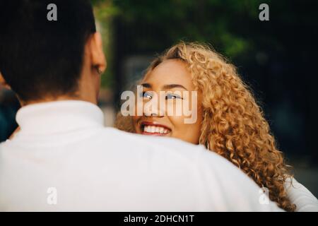 Nahaufnahme einer lächelnden Frau, die einen Freund im Freien ansieht Stockfoto