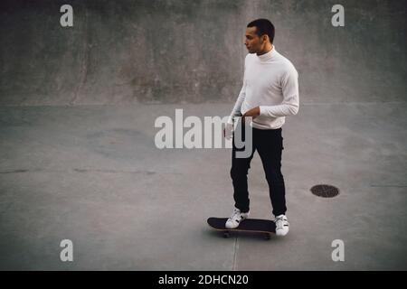 High-Angle-Ansicht des jungen Mannes Skateboarding im Park Stockfoto