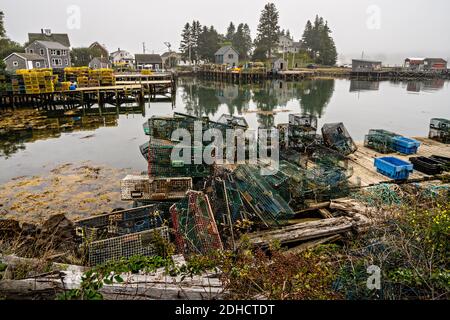 Die Hummerdocks und der Pier stapelten sich an einem nebligen Morgen im malerischen Fischerhafen von Port Clyde, Maine mit Fallen. Stockfoto