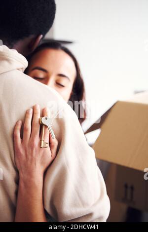 Nahaufnahme der jungen gemischten ethnischen Zugehörigkeit Paar in der Küche stehen Der neuen Heimat Umarmung, wie sie Auspacken Entnahmeboxen zusammen Stockfoto
