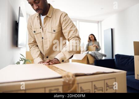 Junges Paar in der Lounge zu Hause Verpackung Entfernung Boxen bereit Für den Hausumzug Stockfoto
