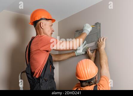 Arbeiter installieren ein Split-System für eine Klimaanlage zu Hause. Stockfoto