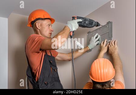 Arbeiter installieren ein Split-System für eine Klimaanlage zu Hause. Stockfoto